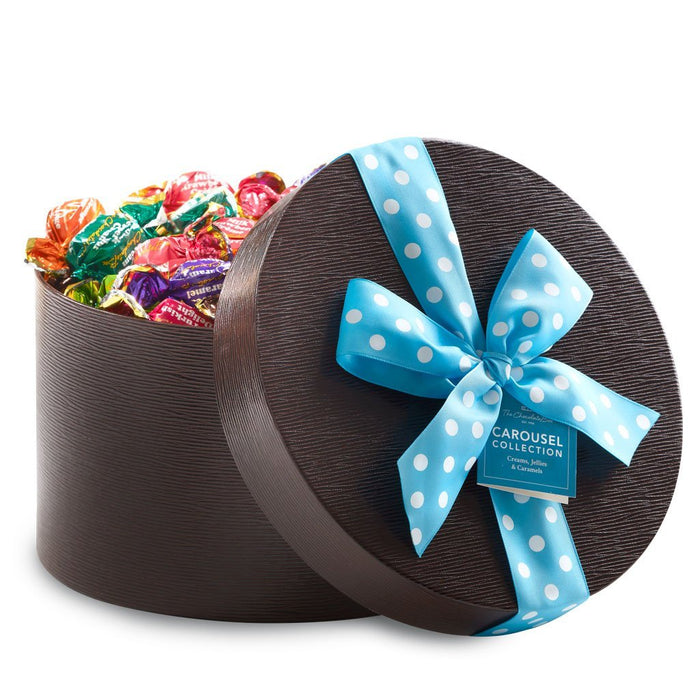 Carousel assortment 1 kilo round keepsake brown box with blue and white spotty ribbon